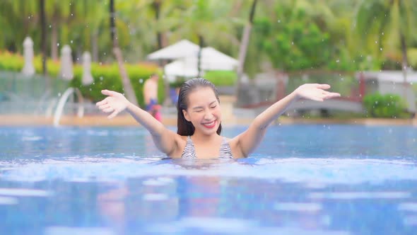 Young asian woman enjoy around outdoor swimming pool for leisure