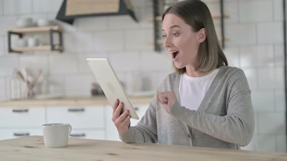 Young Woman Get Surprise on Tablet and Celebrating