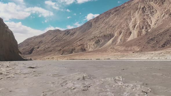 the mind calming video of flow of shyok river in between two mountains and beautiful blue sky in the