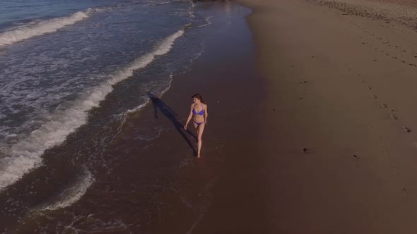 Woman Walking On The Beach