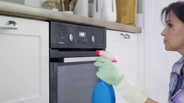 Kitchen Cleaning Woman Washing Oven Door and Panel