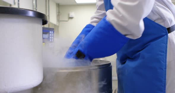 Scientist removing vertical freezer rack from freezer 4k alt