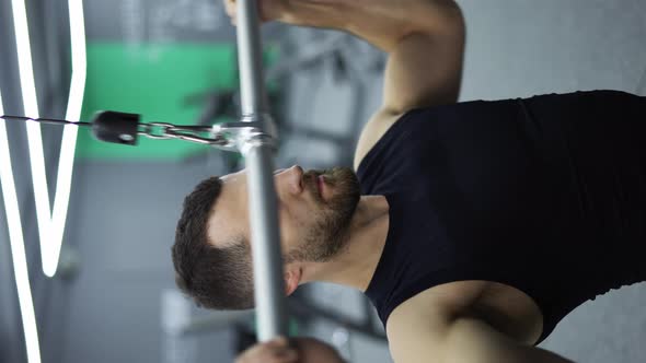 Male Training Chest Muscles Doing Pulls Weight Exercise in a Gym