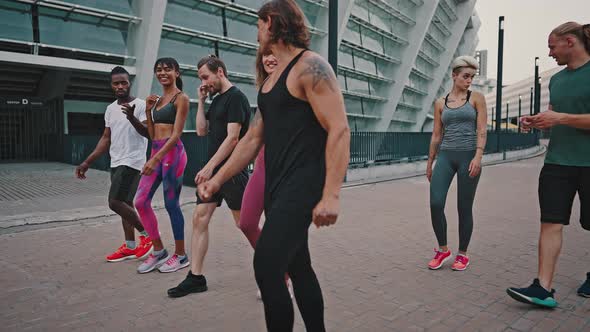 Group of Likeminded Multiracial Friends Walk Together After Completing a Workout