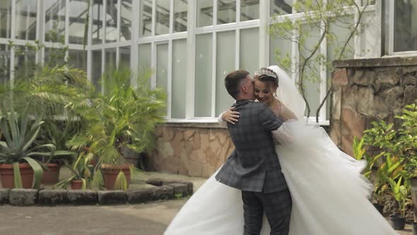 Newlyweds. Caucasian Groom with Bride Walking, Embracing, Hugs in Park. Wedding Couple