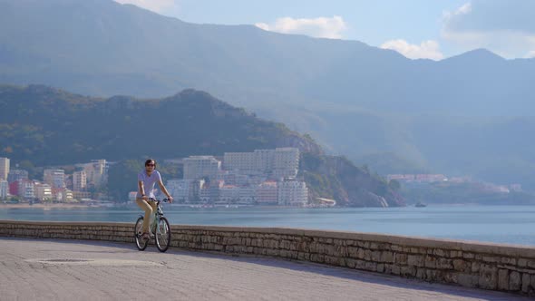 A Young Man Rides a Bicycle in the City of Budva a Famous Tourist Place in Montenegro