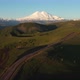 Top view of green field, winding roads and Caucasus mountains.Sunrise above Mount Elbrus - VideoHive Item for Sale