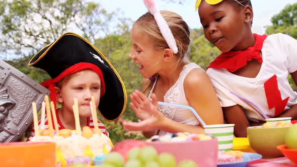 Group of kids in various costumes celebrating birthday alt