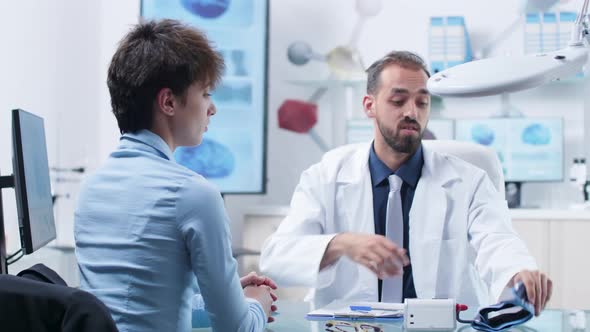 Doctor in Modern Medical Research Facility Measuring Blood Pressure To an Young Woman