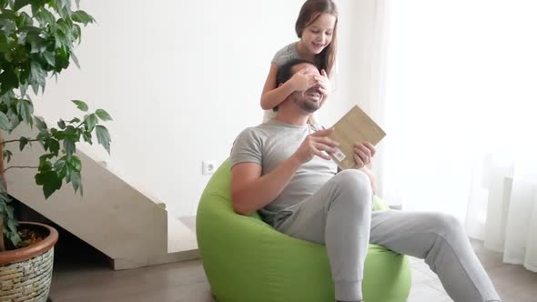 Close Up of Cheerful Teen Girl with Long Hair is Hugging Her Dad and Laughing in the Living Room at