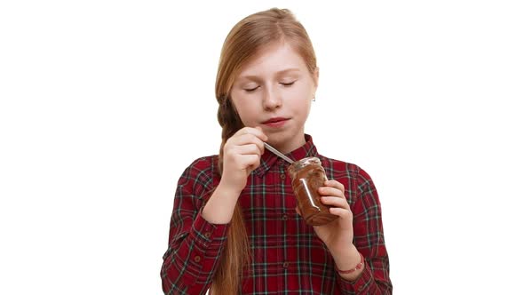 Cute Elementaryschool Aged Caucasian Girl with Plait of Hair Eating Chocolate Spread with Great