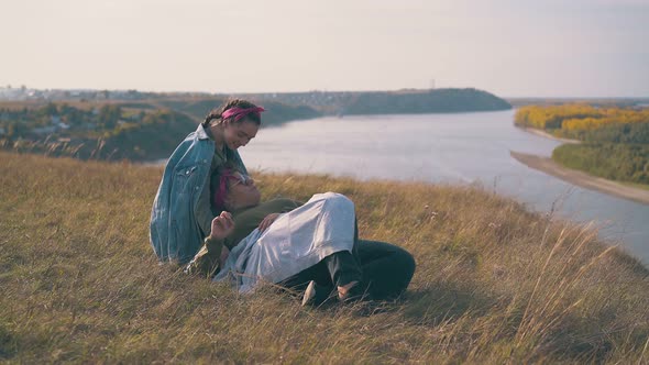 Woman with Girlfriend Spends Time in Camp Against River