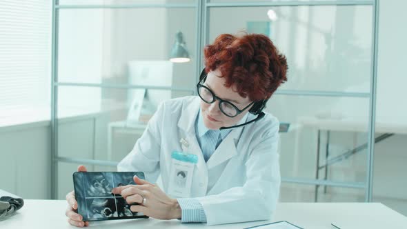 Female Doctor in Headset Explaining Ultrasound Scan on Camera