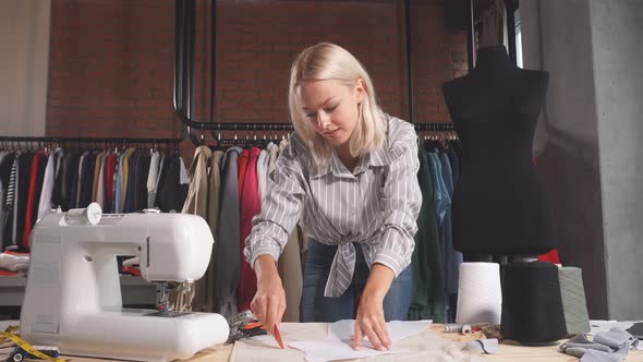 Cheerful Blonde Designer Making Up a Fashion Clothing