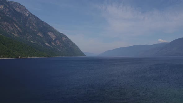 Lake Teletskoye between mountains with blue clear sky in Altai