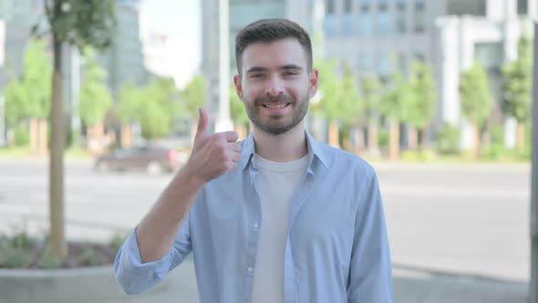 Thumbs Up By Young Man Standing Outdoor