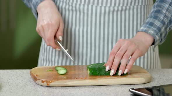 Female Hands Cutting Cucumber