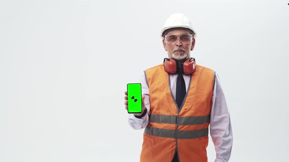 Adult Modern Man Worker in Uniform Holds a Phone with an App in Hand on a White Background the