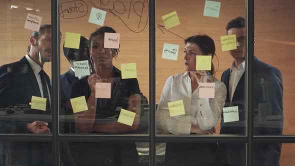 Business Meeting, International Management Team at Work, Team Is Standing Next To a Glass Board with