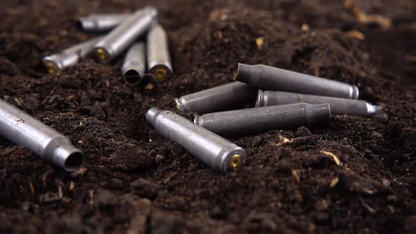 Bullet casings fall to the ground. Slow motion. alt