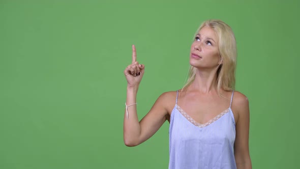 Young Happy Beautiful Businesswoman Thinking While Pointing Up