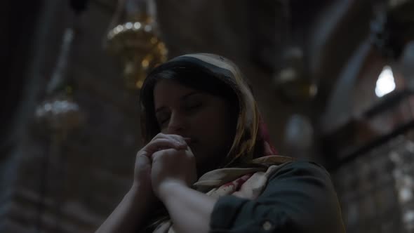 Young woman praying with closed eyes