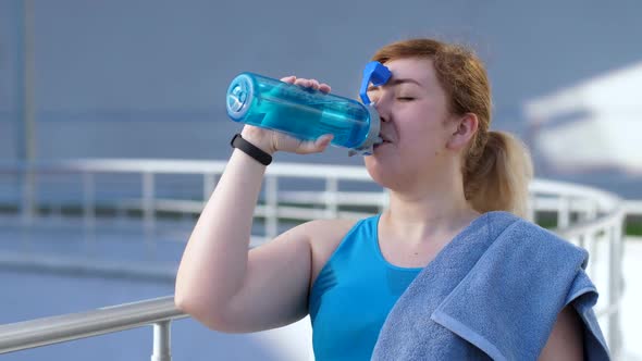 Portrait of Thirsty Female Runner Drinking Water