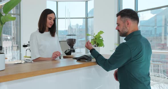 Man Paying for Coffee with Nfc Technology By Smartwatch Contactless on Terminal in Modern Cafe