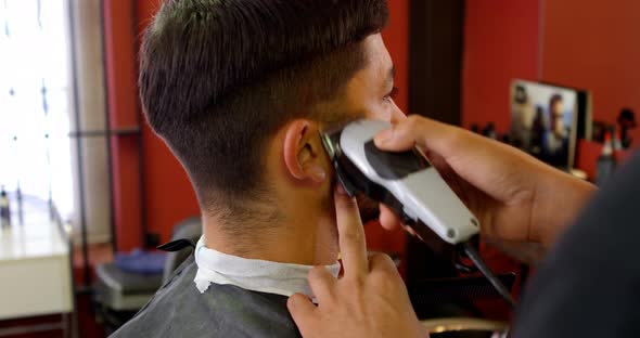 Man getting his hair trimmed with trimmer 