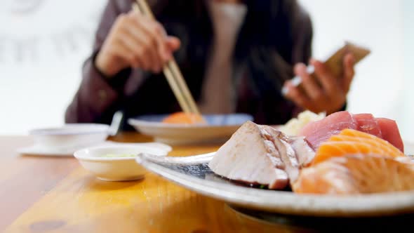 Woman having sushi in restaurant