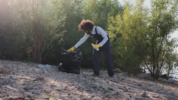 Adult Male Volunteer Pickup and Collecting Garbage on Beach