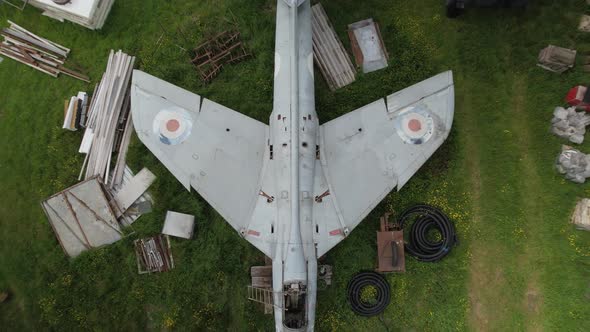 Rising aerial view above wings of distressed Hawker hunter fighter aircraft on British renovation fa