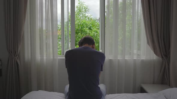 A Young Man in a Mandatory Quarantine. He Sits and Looks Outside the Window. He Stays in One Room