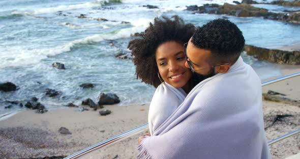 Couple in blanket kissing each other at beach 4k