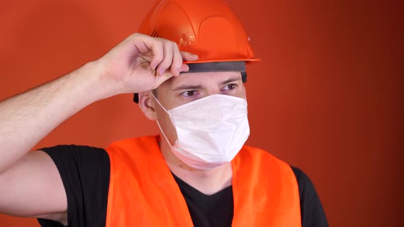 Portrait of Young Man in Medical Mask on His Face on Orange Background