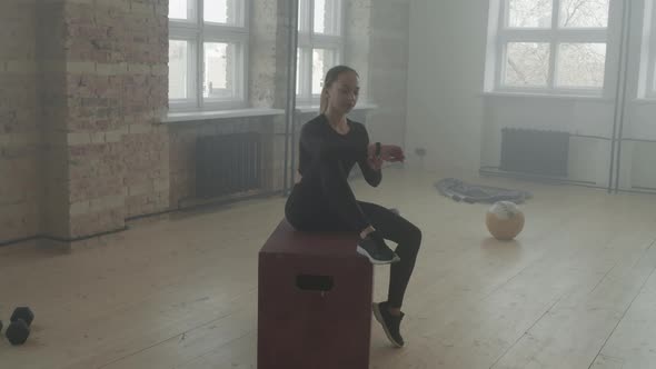 Sportswoman With Smartwatch Resting Between Sets