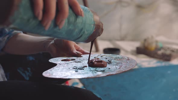 Paint From a Can is Poured Onto the Palette