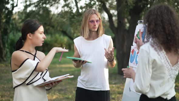 Rack Focus From Young Man Talking Walking Away to Beautiful Woman Explaining Business Strategy