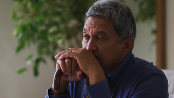 Senior mixed race man holding his head in thought