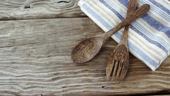 Wooden spoon and fork with napkin on table