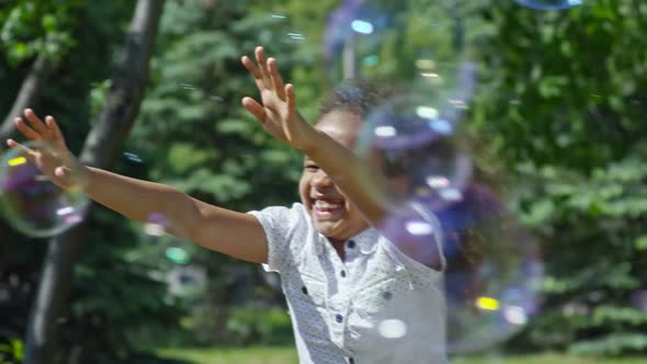 Excited African Girl Enjoying Soap Bubble Show in Park