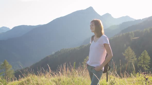 Woman Admiring Sunset at the Top of a Mountain