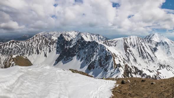 Clouds Moving Fast over Snowy Alpine Mountains in Sunny Winter Nature