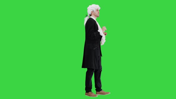 Man in Old-fashioned Laced Frock Coat and White Wig Thinking on a Green Screen, Chroma Key.