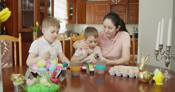 Mom Helps Her Sons Paint Easter Eggs