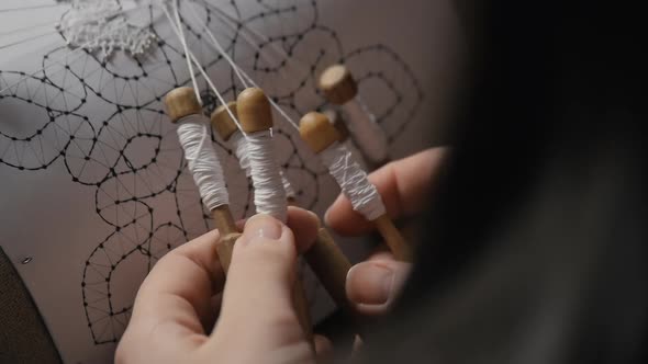 Female Hands Weaving Lace with Bobbins