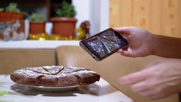 Female Hands Shoots Video of a Chocolate Pie in Kitchen on a Smart Phone