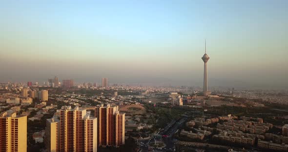Milad Tower Tehran Iran and Block Buildings in Sunset Time landscape of Blue Sky Above Air Pollution