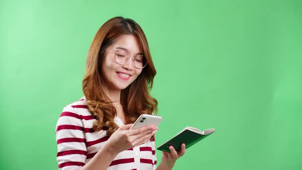 Asian young woman book ticket with her passport in hands in studio with chroma key background.