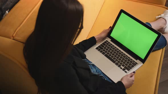 Young Woman Using Laptop with Green Screen Lying on the Couch Sofa at the Home End Working Close